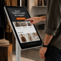 Une cliente utilisant un écran tactile dans un magasin moderne, représentant les nouvelles technologies du commerce